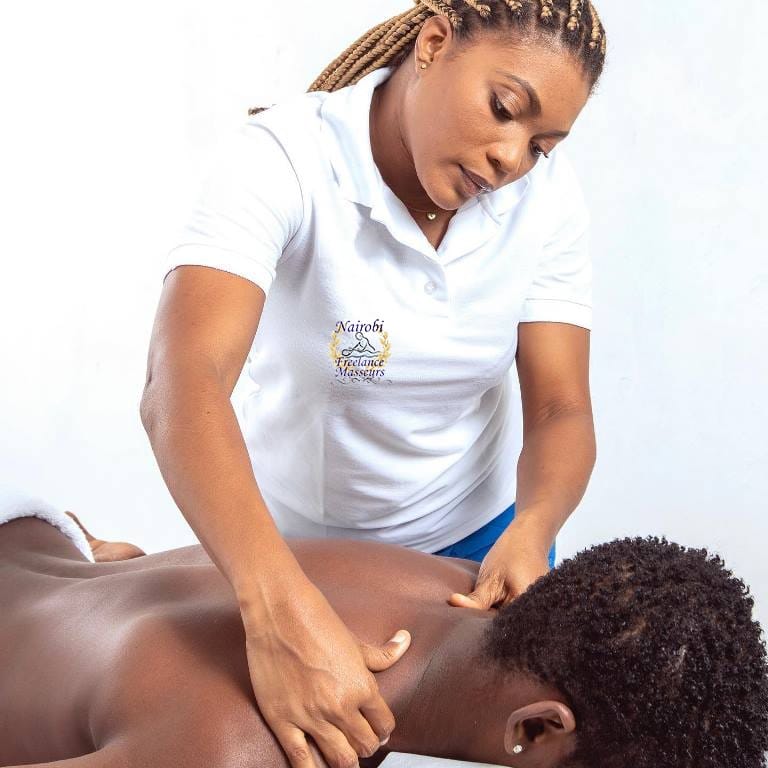 Masseuse performing shoulder massage on a client